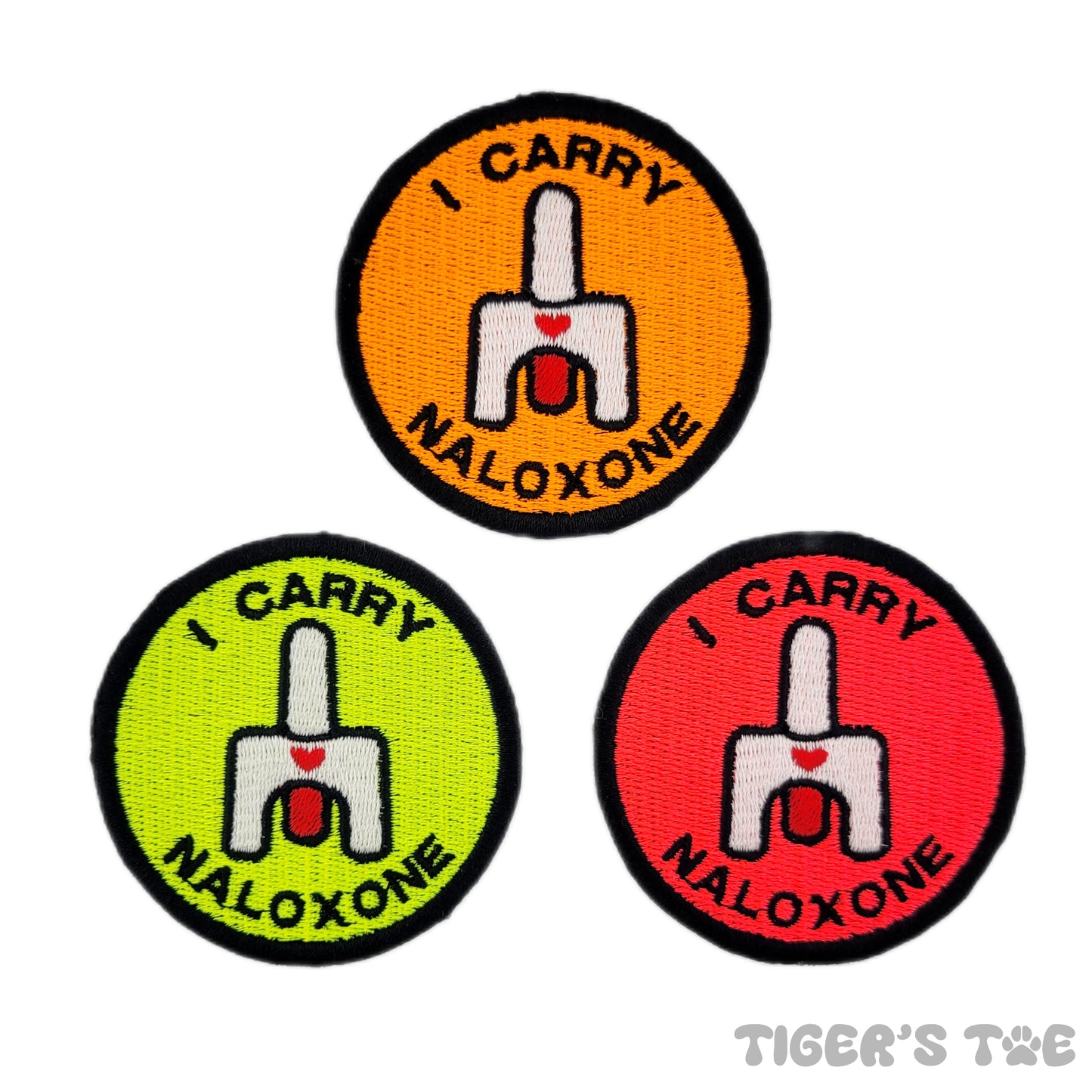 Three embroidered patches with the text 'I CARRY NALOXONE' and a graphic of nasal spray. The patches are in orange, yellow, and pink colors.