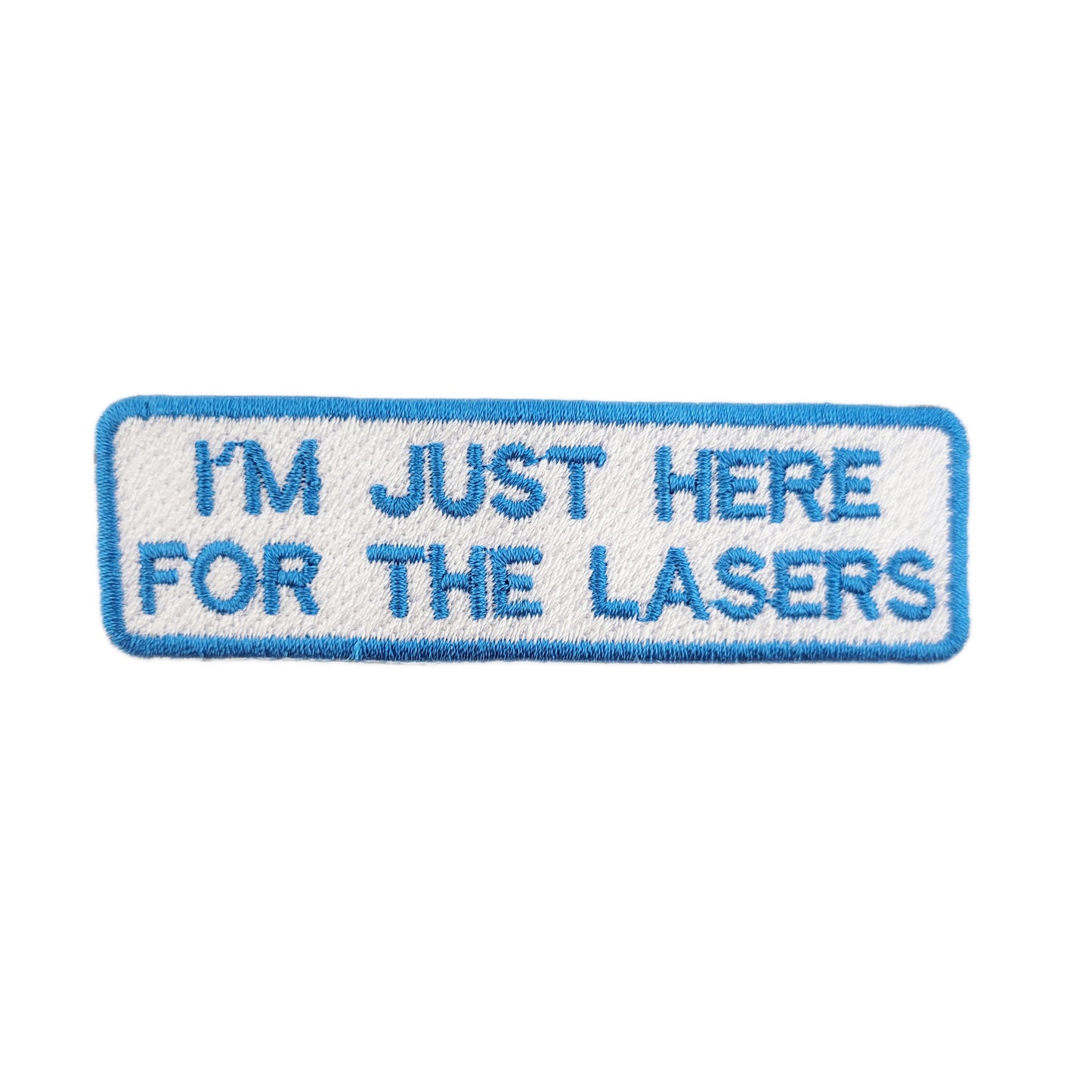 Embroidered patch with text 'I'm just here for the lasers' written in blue text on a white background
