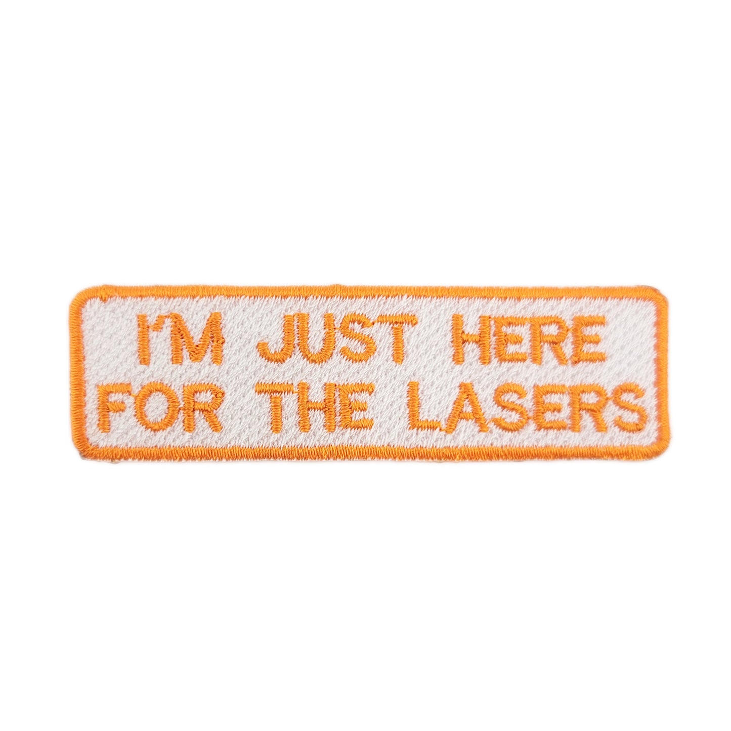 Embroidered patch with text 'I'm just here for the lasers' written in orange text on a white background