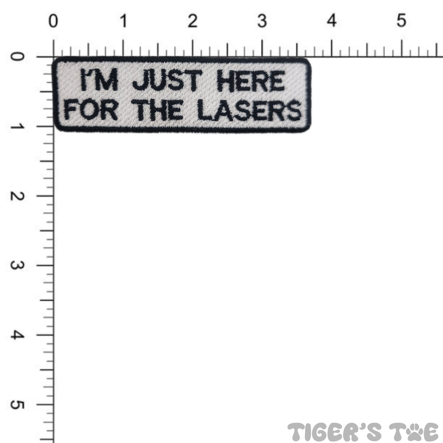 Embroidered patch with 'I'm just here for the lasers' text on a white background with a ruler for scale.