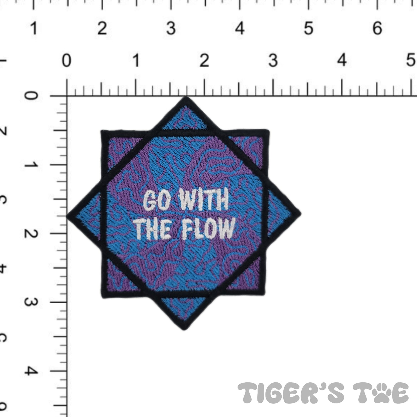 Embroidered patch of a blue and purple flow star with decorative swirls. The center of the flow star reads "GO WITH THE FLOW" in white text. The patch is next to a ruler to help visualize the size, approximately 3.50 x 3.50 inches.