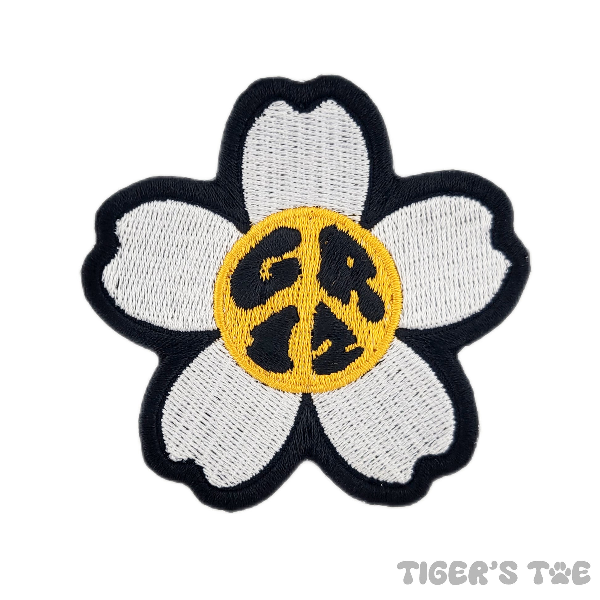 Embroidered patch of a 5-petal white daisy with a yellow center. The center also spells out "GRiZ" in the shape of a peace sign, hence the name "GRiZ Peace Daisy"