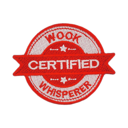 Red and white patch with 'CERTIFIED WOOK WHISPERER' text on a white background