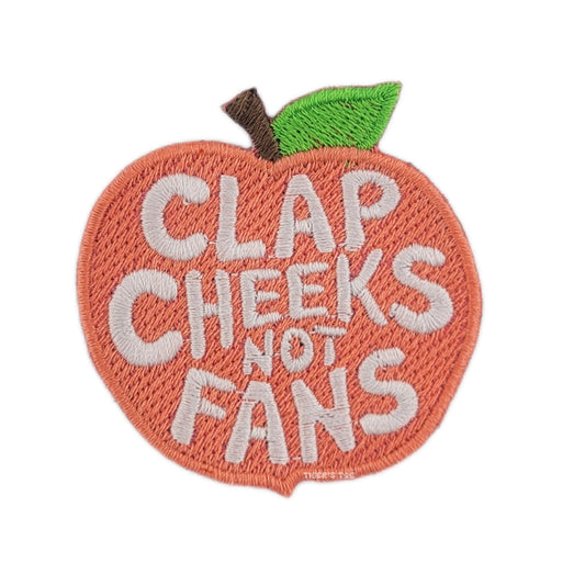 Embroidered patch shaped like a peach with text 'CLAP CHEEKS NOT FANS' on a white background