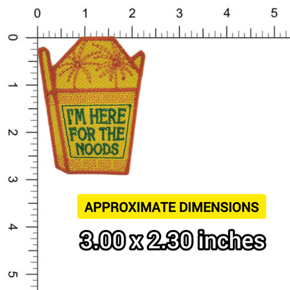 Patch of a yellow noodle takeout container with text 'I'm here for the noods' written in green shown on a ruler for scale