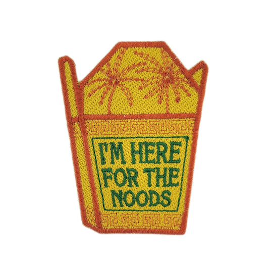 Patch of a yellow noodle takeout container with text 'I'm here for the noods' written in green on a white background
