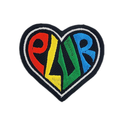 Heart-shaped patch with colorful letters spelling "plur" on a white background