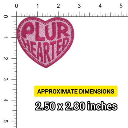Heart-shaped patch with 'PLUR HEARTED' text on a ruler for size reference