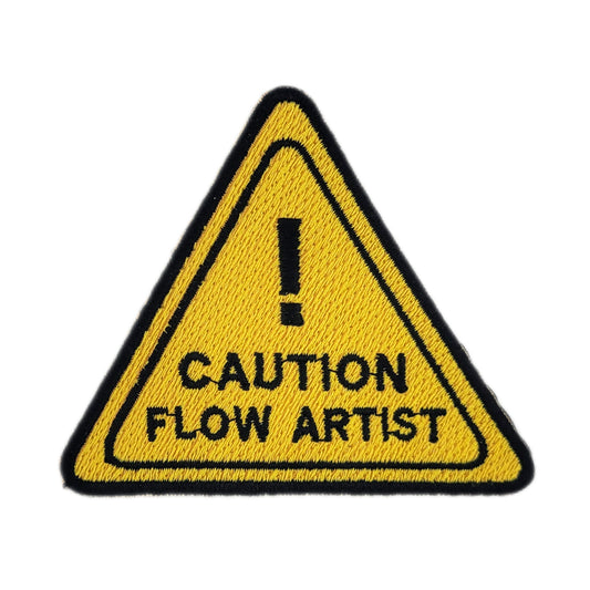 Yellow triangle warning sign with 'Caution Flow Artist' text on a white background