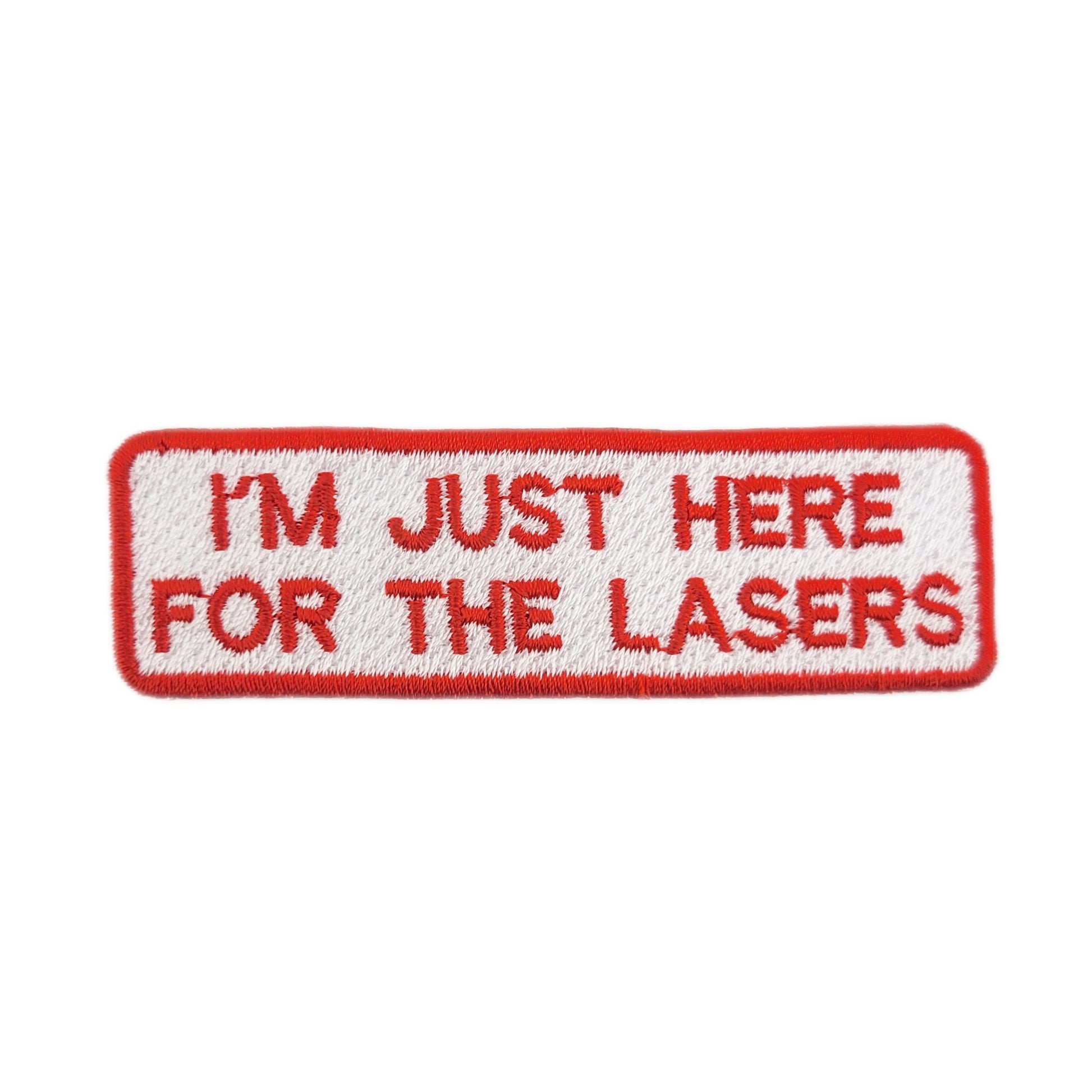 Embroidered patch with text 'I'm just here for the lasers' written in red on a white background