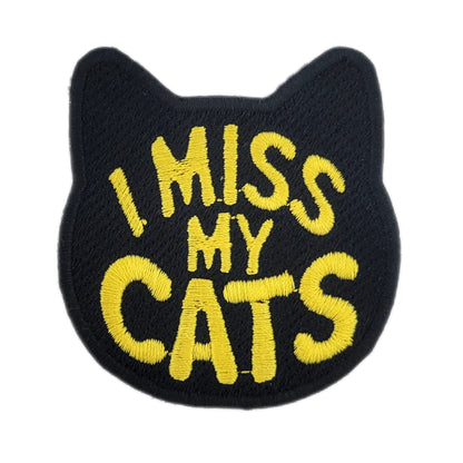 Black patch with yellow text 'I MISS MY CATS' on a white background